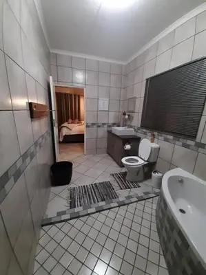 a bathroom with a tub and a toilet and a sink at Maningwe in Marloth Park