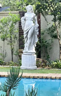 a statue of a woman standing next to a pool at Waterfall City Guest Lodge in Sandton