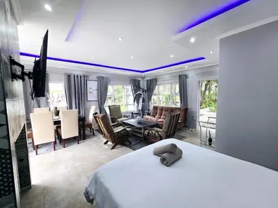 a hotel room with a bed and a dining room at Waterfall City Guest Lodge in Sandton