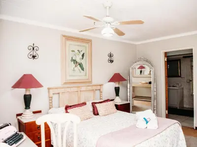 a bedroom with a bed and a ceiling fan at Grace View Guest House in Secunda