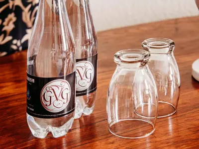 three glass bottles sitting on top of a wooden table at Grace View Guest House in Secunda