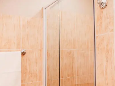 a shower with a glass door in a bathroom at Grace View Guest House in Secunda