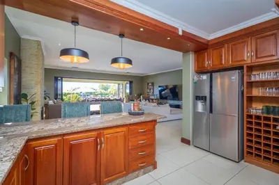 a kitchen with wooden cabinets and a stainless steel refrigerator at Pecanwood Retreat - Pecanwood Golf Estate - Hartbeespoort in Hartbeespoort