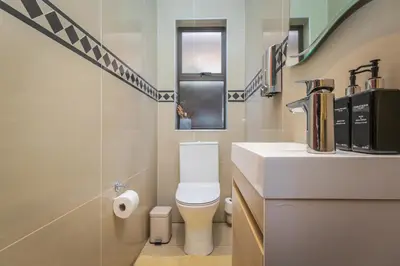 a bathroom with a white toilet and a sink at Pecanwood Retreat - Pecanwood Golf Estate - Hartbeespoort in Hartbeespoort