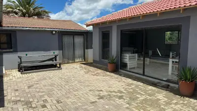 a house with a bench and a patio at K K K Guesthouse in Secunda