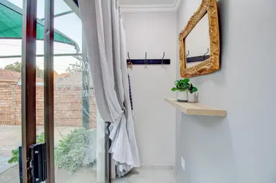 a room with a window and a mirror on the wall at Luxurious self-catering villa, step-free and pet-friendly in Centurion