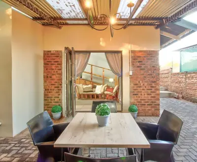 a dining room with a wooden table and chairs at Luxurious self-catering villa, step-free and pet-friendly in Centurion