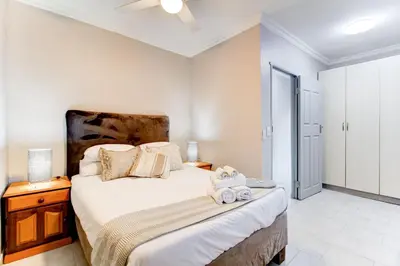 a bedroom with a bed with towels on it at Luxurious self-catering villa, step-free and pet-friendly in Centurion