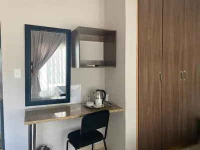 a kitchen with a counter with a chair and a mirror at Sisonke Guest House in Kwamhlanga
