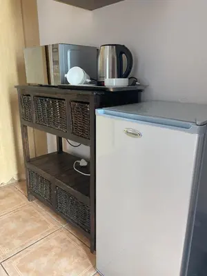 a small kitchen with a refrigerator and a microwave at Sisonke Guest House in Kwamhlanga