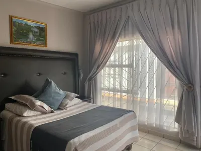 a bedroom with a bed and a large window at Sisonke Guest House in Kwamhlanga