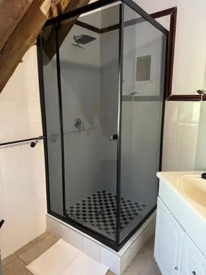 a glass shower in a bathroom with a sink at Blue Gum Cottage in Midrand