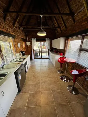 a kitchen with a counter and a table in it at Blue Gum Cottage in Midrand
