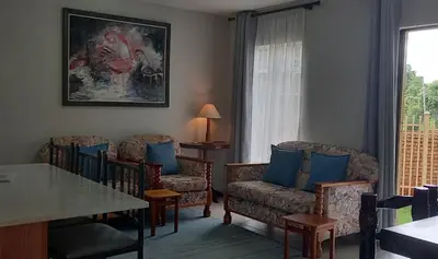 a living room with chairs and a table at Faerie Glen, No Loadshedding, Short or Long Stays, Fast Wi-Fi in Pretoria