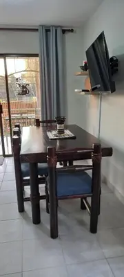a dining room table with a bench and a television at Faerie Glen, No Loadshedding, Short or Long Stays, Fast Wi-Fi in Pretoria