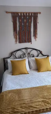 a bedroom with a large bed with yellow pillows at Faerie Glen, No Loadshedding, Short or Long Stays, Fast Wi-Fi in Pretoria