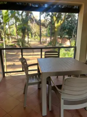 a table and chairs on a balcony with a table and a view at Lowveld Sleepover in Tzaneen