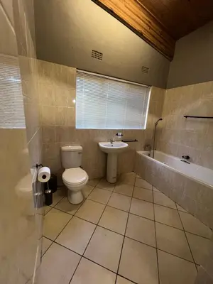 a bathroom with a toilet and a sink and a tub at Lowveld Sleepover in Tzaneen