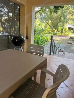 a dog walking on a patio with a table and chairs at Lowveld Sleepover in Tzaneen