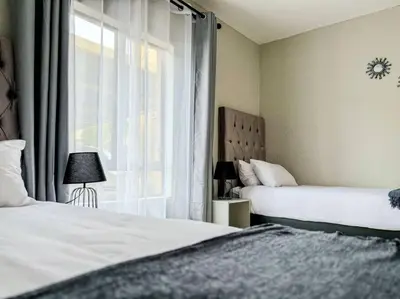 a bedroom with two beds and a window at Self checkin - Modern Haven 2 Bedroom 43 in Nelspruit