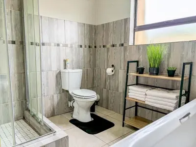 a bathroom with a toilet and a bath tub at Self checkin - Modern Haven 2 Bedroom 43 in Nelspruit