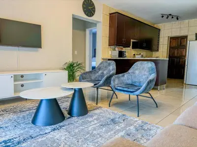 a living room with two chairs and a table at Self checkin - Modern Haven 2 Bedroom 43 in Nelspruit