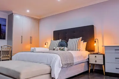a bedroom with a large bed with a large headboard at Siesta Manor Guesthouse in Mokopane
