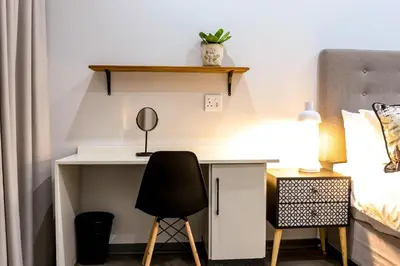 a bedroom with a desk with a chair and a bed at Siesta Manor Guesthouse in Mokopane