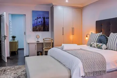 a bedroom with a large bed and a table at Siesta Manor Guesthouse in Mokopane