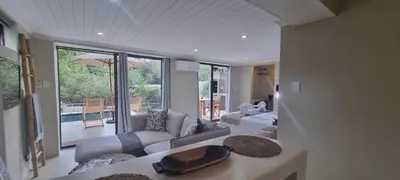 a living room with couches and a living room with a view at Buffalo Thorn Villa next to Kruger National Park in Marloth Park