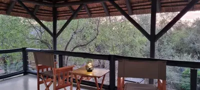 a room with a table and chairs on a balcony at Buffalo Thorn Villa next to Kruger National Park in Marloth Park