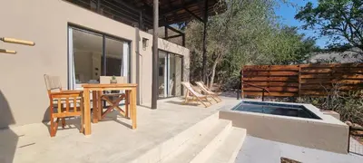 a patio with a table and chairs and a pool at Buffalo Thorn Villa next to Kruger National Park in Marloth Park