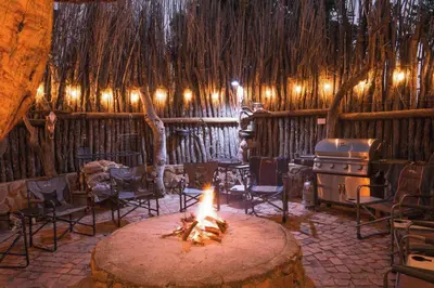 a room with a fireplace and chairs and a fire pit at The Sanctuary in Mabalingwe Nature Reserve in Mabula
