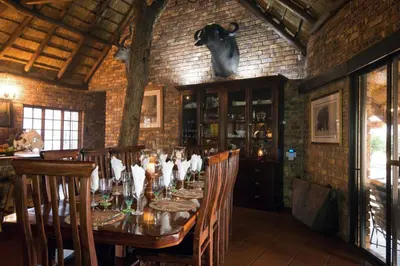 a dining room with a long table and chairs at The Sanctuary in Mabalingwe Nature Reserve in Mabula