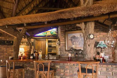 a bar in a restaurant with a brick wall at The Sanctuary in Mabalingwe Nature Reserve in Mabula