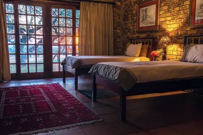 a bedroom with two beds and a large window at The Sanctuary in Mabalingwe Nature Reserve in Mabula