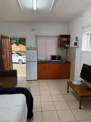 a kitchen with a white refrigerator and a table at Aviation Stay in Kempton Park