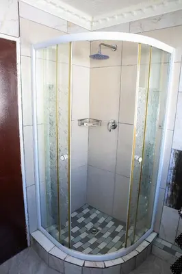 a shower with a glass enclosure in a bathroom at Bonnie house in Crocodile Valley Estates