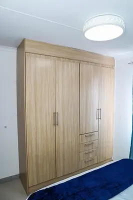 a large wooden cabinet in a bedroom with a bed at Bonnie house in Crocodile Valley Estates
