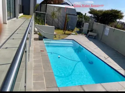 a swimming pool on the side of a house at Ladybug ladybug in Midrand