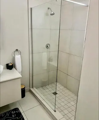 a shower with a glass door in a bathroom at Ladybug ladybug in Midrand