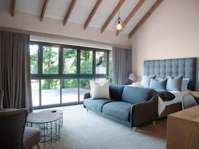 a living room with a blue couch and a large window at Whiskey Creek in Dullstroom