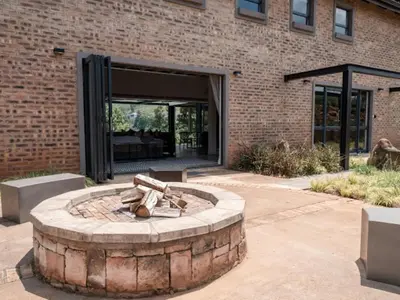 a fire pit in front of a brick building at Whiskey Creek in Dullstroom