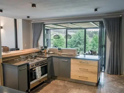 a kitchen with a stove and a large window at Whiskey Creek in Dullstroom