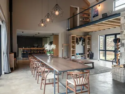 a dining room with a large wooden table and chairs at Whiskey Creek in Dullstroom