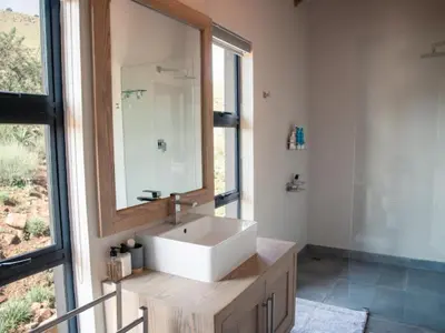 a bathroom with a white sink and a mirror at Whiskey Creek in Dullstroom