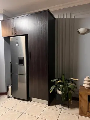 a stainless steel refrigerator in a room with a plant at Bluestream Villas in Pretoria