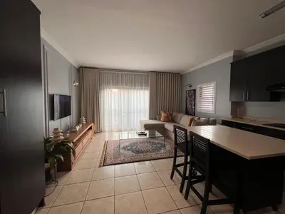a kitchen and living room with a couch and a table at Bluestream Villas in Pretoria