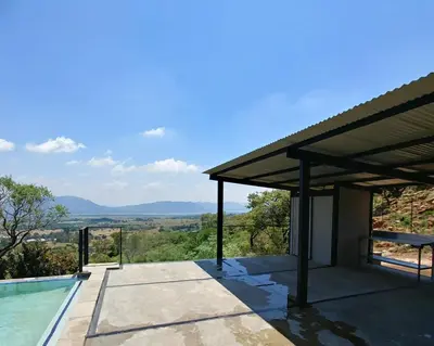 a house with a swimming pool and a roof at Sky Lodge in Hartbeespoort