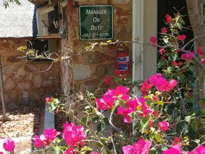 a sign on the side of a building with pink flowers at Sky Lodge in Hartbeespoort